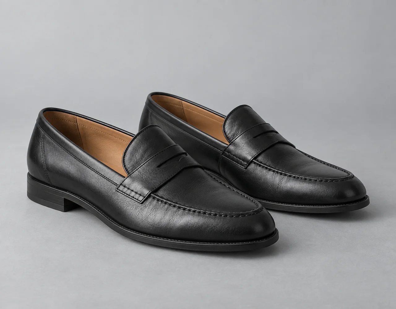 Matching black leather penny loafers with tan lining and stitched uppers