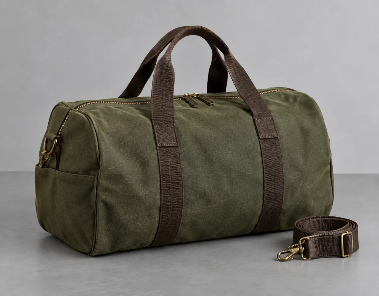 Olive canvas travel duffel with brown webbing handles and detachable shoulder strap